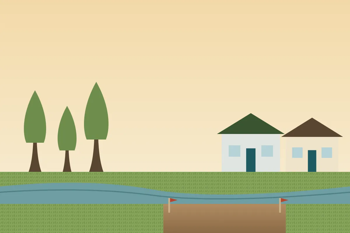 A cleared home site at the edge of a cypress-lined bayou with new houses nearby
